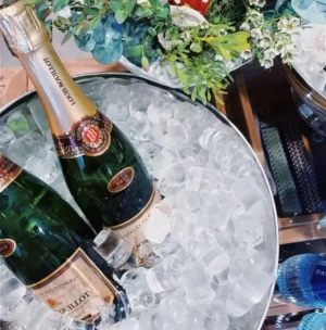 Two bottles of champagne nestled in a bucket filled with ice, ready for celebration.