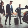 Business professionals in suits and ties entering a car, ready for a meeting or event.