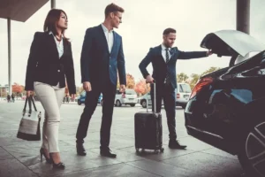 Business professionals in suits and ties entering a car, ready for a meeting or event.